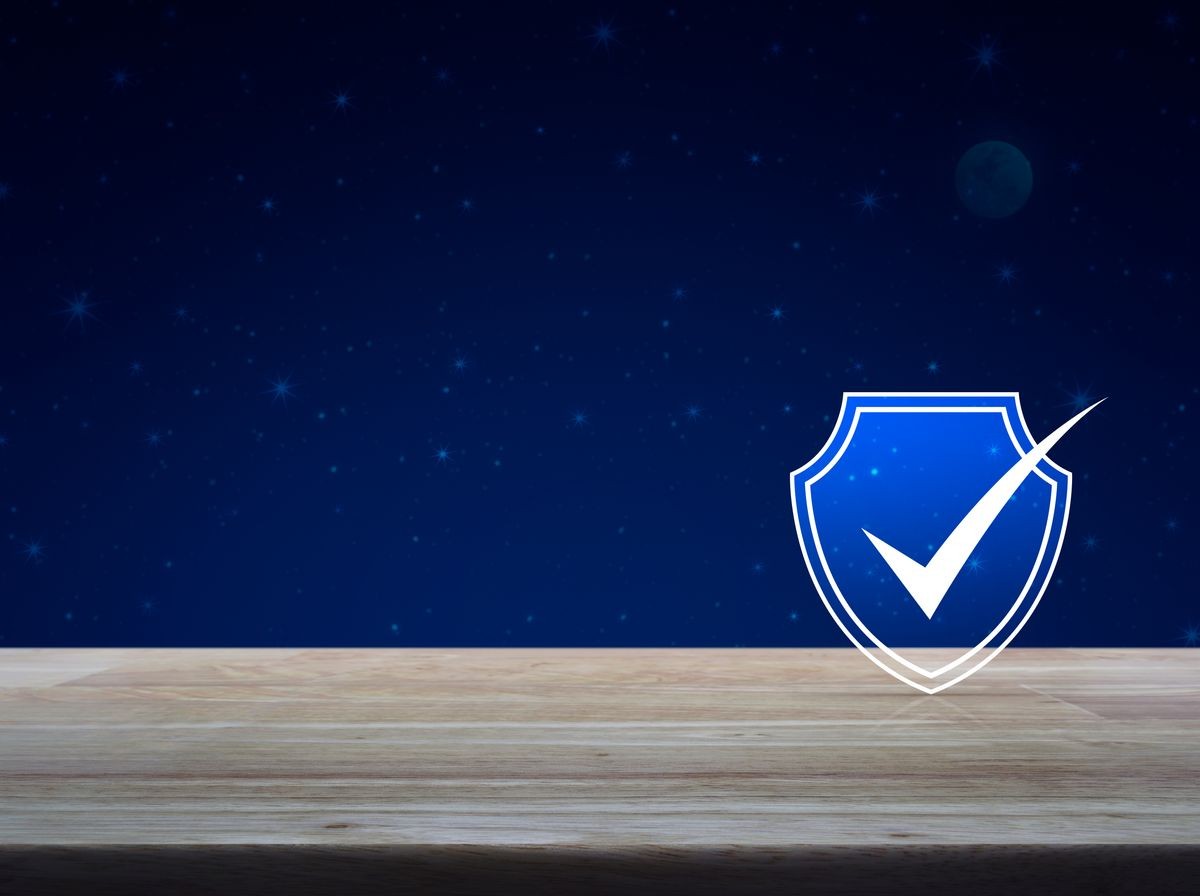 Security shield with check mark flat icon on wooden table over fantasy night sky and moon, Technology internet cyber security and anti virus concept